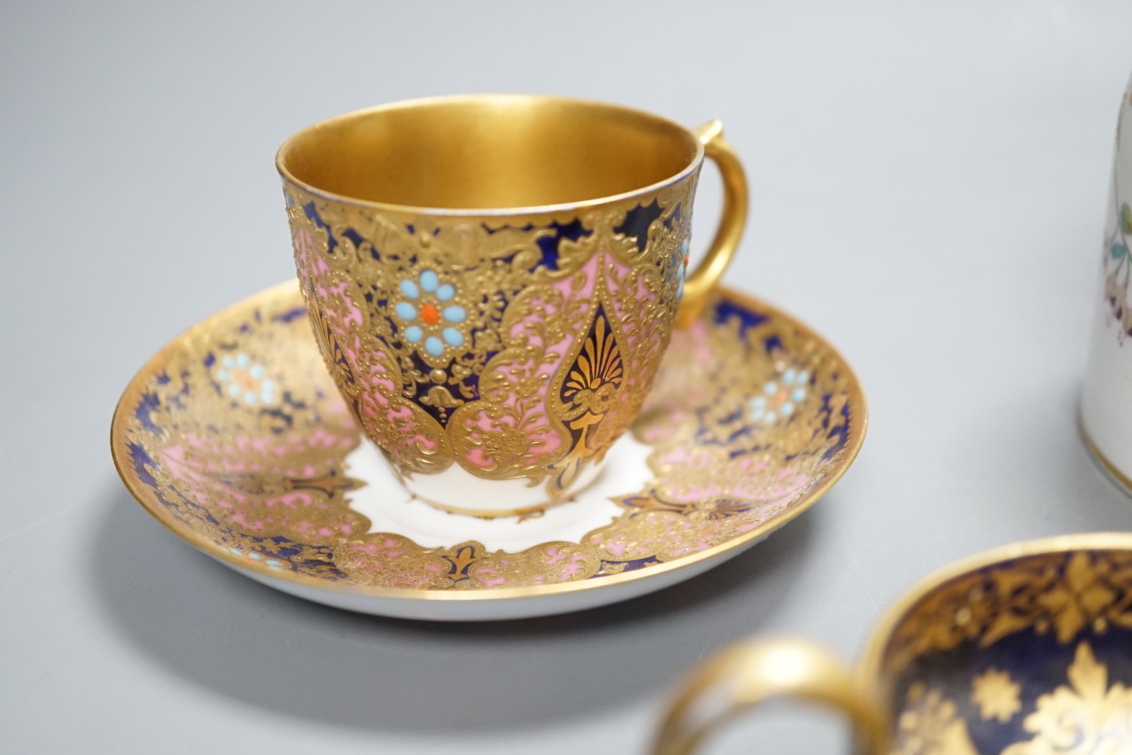 A 19th century Coalport fan shaped dish painted with a Loch scene, two small cup with twin handles decorated with raised gilding on a cobalt blue ground with crown marks, a Copeland jewelled cup and saucer with blue grou